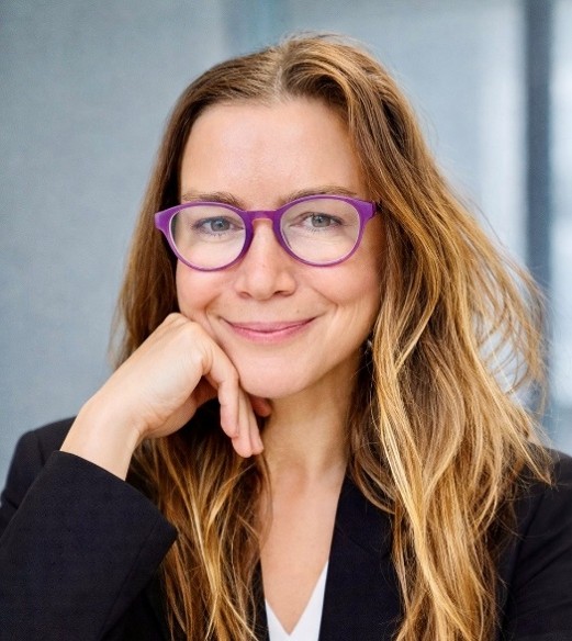 Professional picture of a woman wearing glasses with her chin resting on her hand.