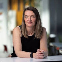 Picture of a professional woman leaning on a table.
